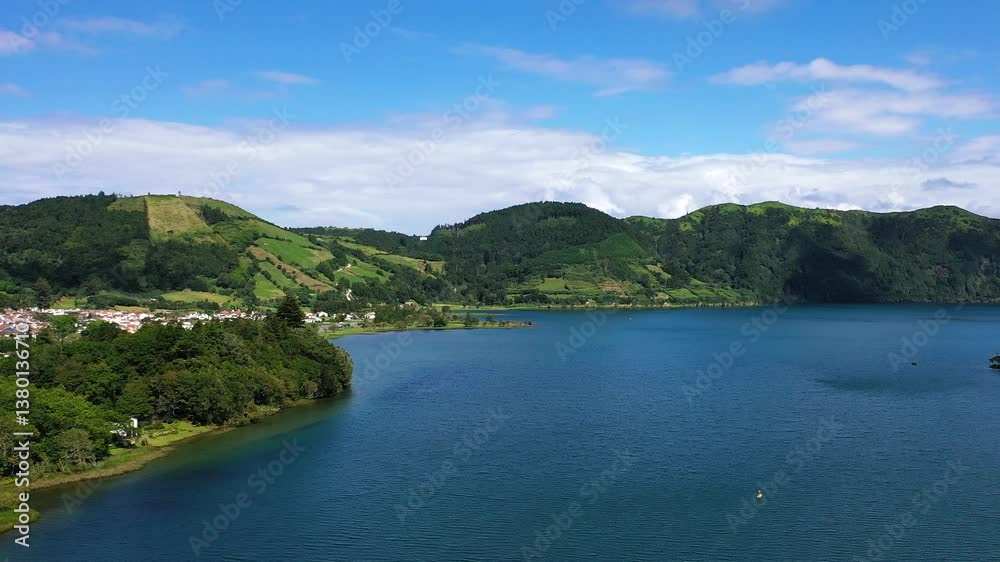 Discover breathtaking views of a serene lake surrounded by vibrant vegetation and rolling hills in the Azores. Experience nature's tranquility and beauty. Discover breathtaking views of a serene lake surrounded by vibrant vegetation and rolling hills in the Azores. Experience nature's tranquility and beauty.