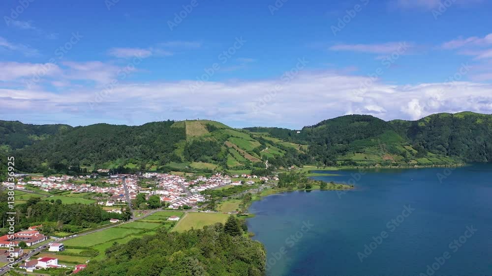 Discover breathtaking views of a serene lake surrounded by vibrant vegetation and rolling hills in the Azores. Experience nature's tranquility and beauty. Discover breathtaking views of a serene lake surrounded by vibrant vegetation and rolling hills in the Azores. Experience nature's tranquility and beauty.