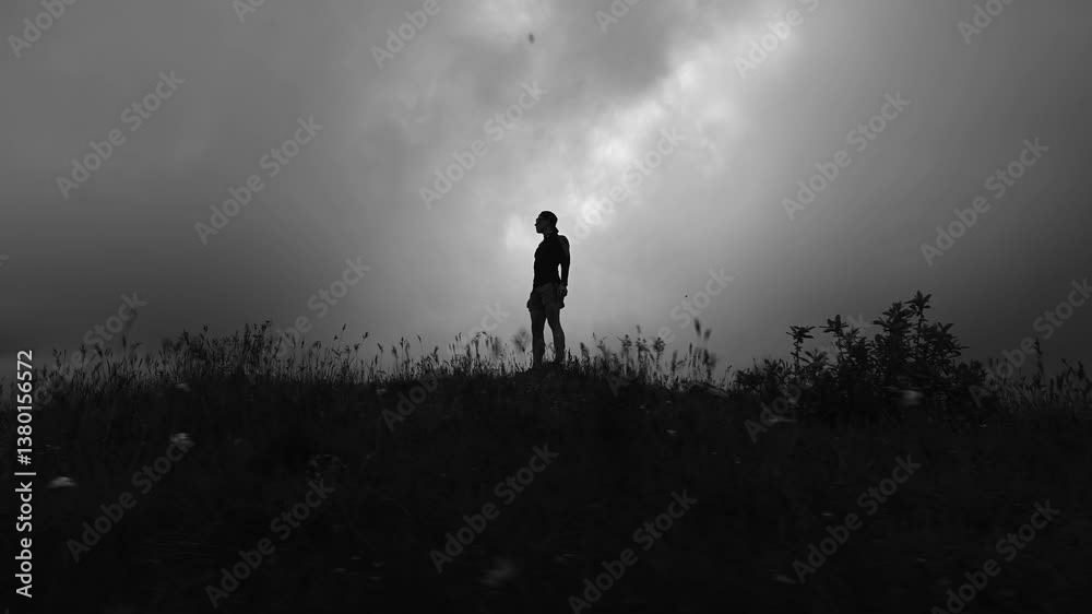 runner stands on a field in thick grass after an intense workout. Regular exercise will help you achieve amazing results. Rest during a long-distance run runner stands on a field in thick grass after an intense workout. Regular exercise will help you achieve amazing results. Rest during a long-distance run