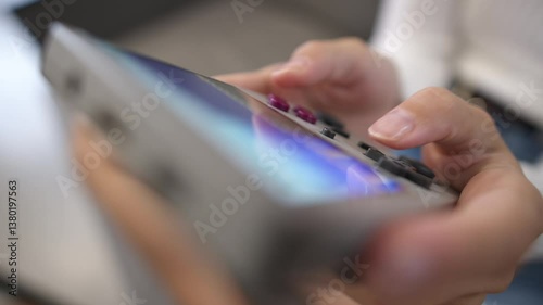 Top view of beautiful young woman sitting on sofa at home enjoying video game on portable retro console