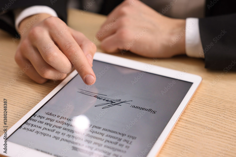 Electronic signature. Man using tablet at wooden table, closeup Electronic signature. Man using tablet at wooden table, closeup