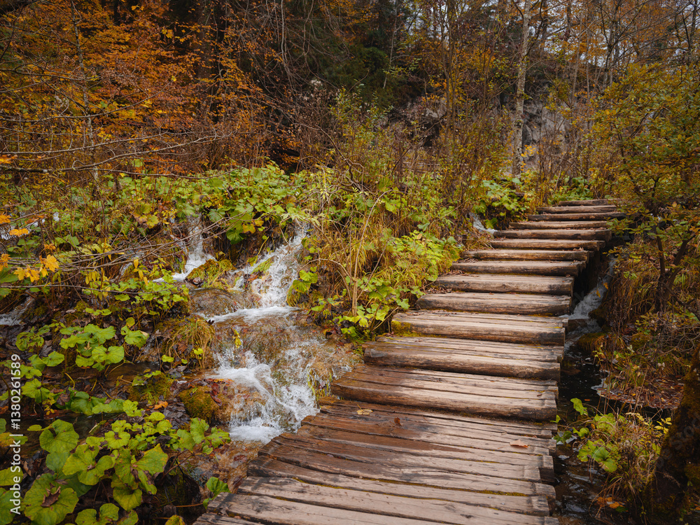 Obraz premium Wooden walkpath in Plitvice National Park. Splendid autumn in forest with pure water lake. Picturesque landscape of Croatia, Europe. Beauty of nature concept background.