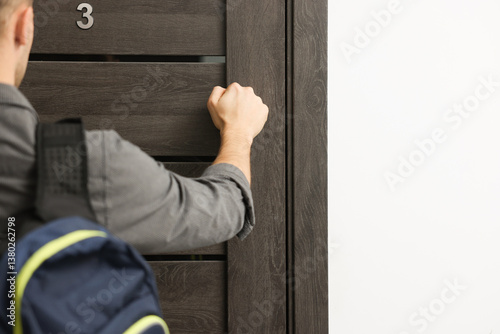 Man knocking on door to his friends apartment, closeup