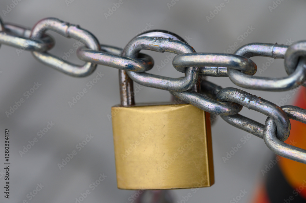 Metallic chain secured with a shiny golden padlock, symbolizing strength and safety in a bustling urban environment Metallic chain secured with a shiny golden padlock, symbolizing strength and safety in a bustling urban environment