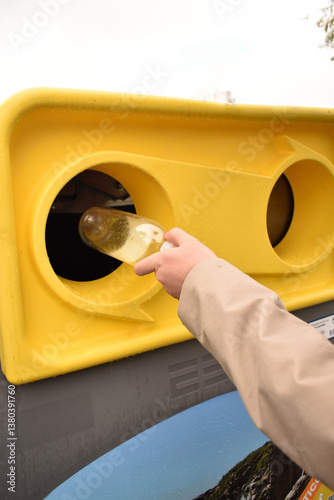 The man protects the environment and sorts garbage by throwing plastic into a special container