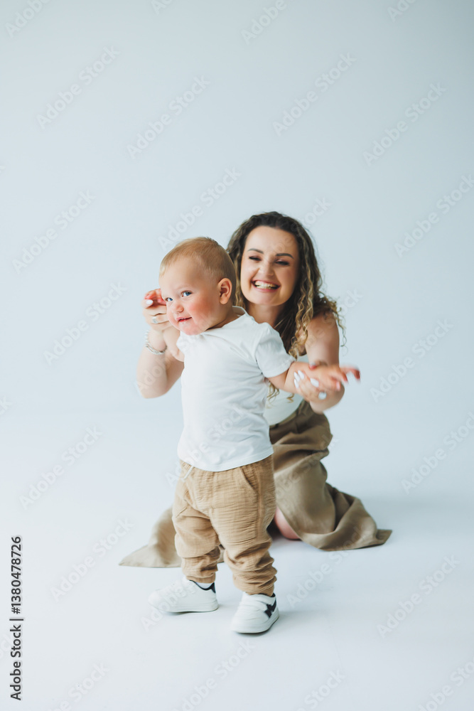 A Heartwarming and Joyful Moment Captured Delightful and Playful Interaction Between a Loving Mother and Her Curious Toddler Happening in a Bright Studio Setting that Radiates Happiness and Love