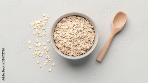 Natural oats in bowl with wooden spoon, emphasizing healthy nutr