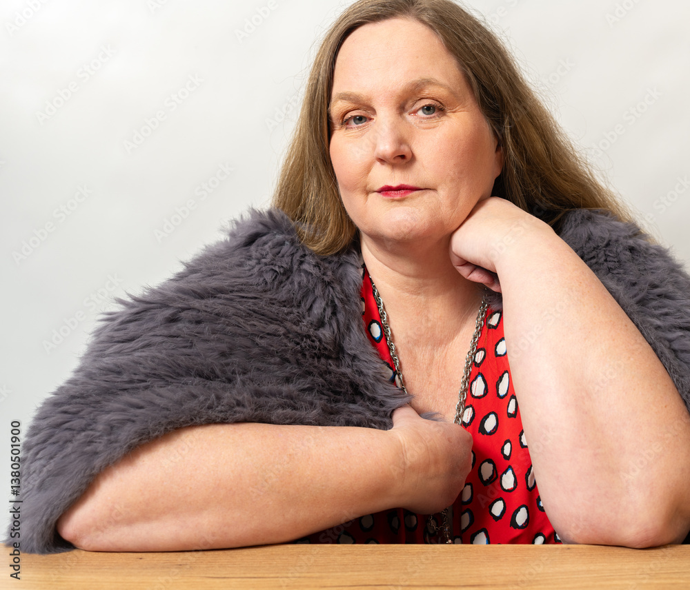 Frau in einer Kaninchenfell Jacke und ein rotes Kleid vor einem weißen Hintergrund