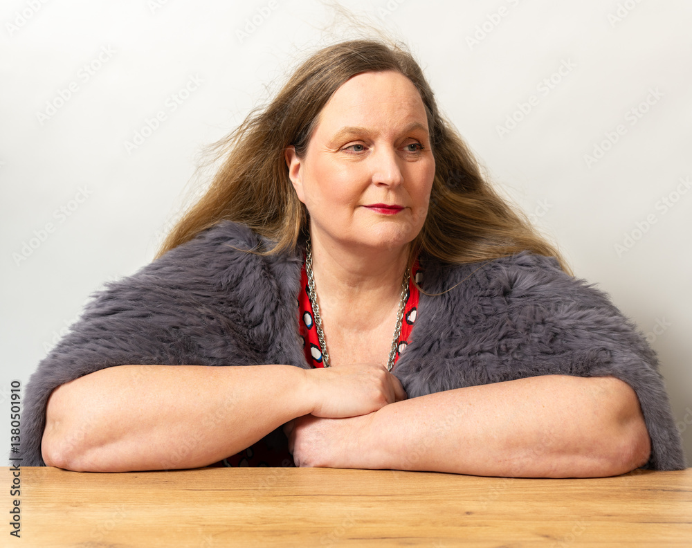 Frau in einer Kaninchenfell Jacke und ein rotes Kleid vor einem weißen Hintergrund