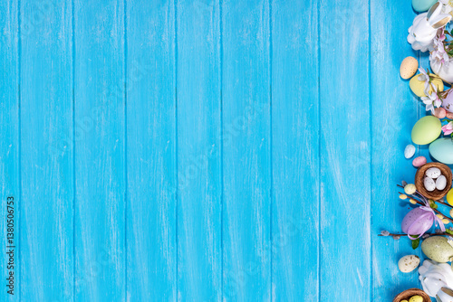 Spring Easter holiday top view flat lay background with eggs, bunny rabbits and spring flowers. Bright colorful greeting card background with copy space.