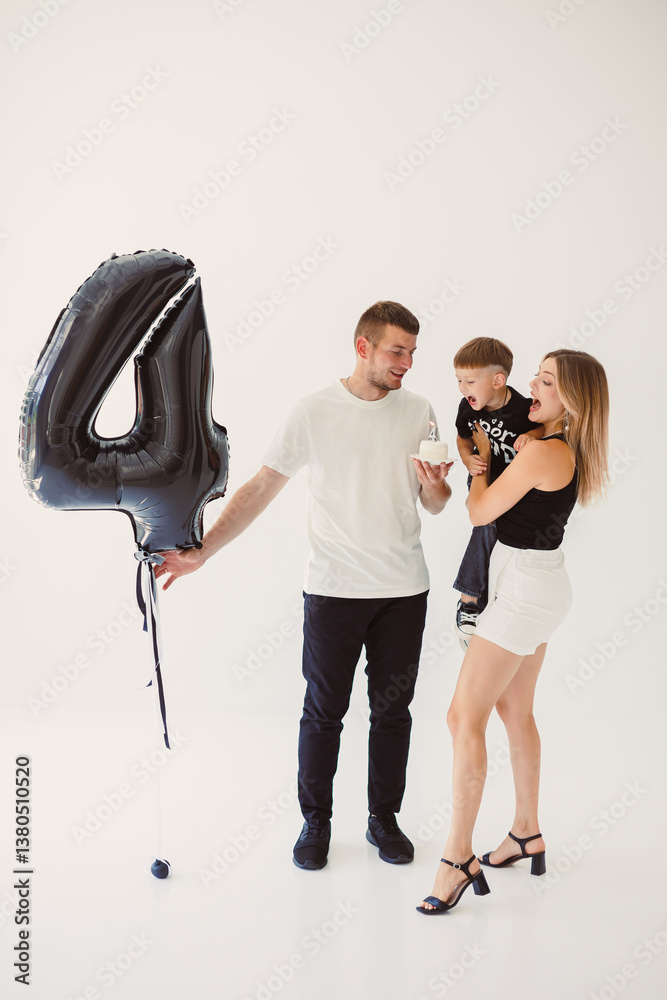 A joyful and happy family is seen celebrating a very special occasion together, surrounded by a large, colorful balloon shaped like the number four, symbolizing this moment of fun and love