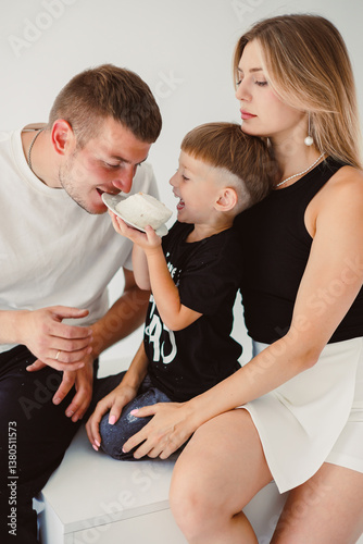 Obraz na płótnie A Heartwarming Family Bonding Moment Captured Delightful and Playful Interaction Between Loving Parents and Their Joyful Child in a Bright, Modern Setting Full of Warmth and Positivity w salonie