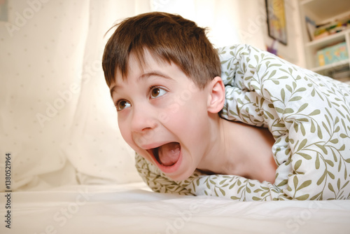 The child was rolled up in a blanket and his feet are tickling. Wrapped boy needs help he is ticklish. Bad joke and game. Psychological problems. Physical touch against will. Unpleasant sensations.