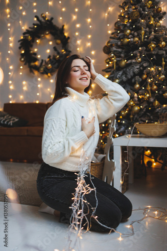 Cute girl in New Year's locations in a cozy living room. Woman at home for the new year.