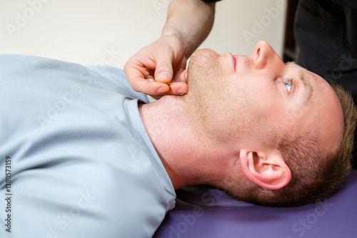 Obraz na płótnie Chiropractic Treatment This involves the Professional Manual Manipulation of a Patients Jaw during a Therapy Session aimed at improving health and wellness through specialized techniques w salonie