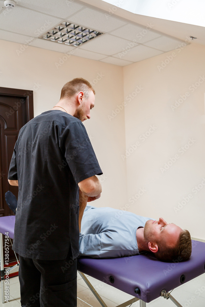 A therapist is currently providing treatment to a patient who is lying on an examination table within a professional medical office setting, which embodies a sense of comfort and healing