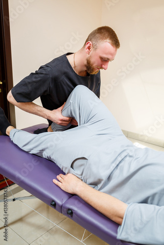Obraz na płótnie An experienced Physical Therapist is offering specialized Knee Manipulation Therapy to enhance mobility and alleviate knee discomfort for patients seeking relief and improved range of motion w salonie