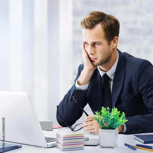 Stressed, tired businessman or having headache hold hand his cheek, in corporate black jacket use laptop at office workplace desk. Portrait square image - pessimistic fall thinking, ill business man