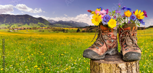 Obraz na płótnie Wanderung in den Bergen mit Bergstiefel mit Blumen - FOTOMONTAGE w salonie