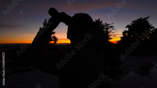 Obraz na płótnie Amateur astronomer looking at the evening skies, observing planets, stars, Moon and other celestial objects with binoculars. w salonie