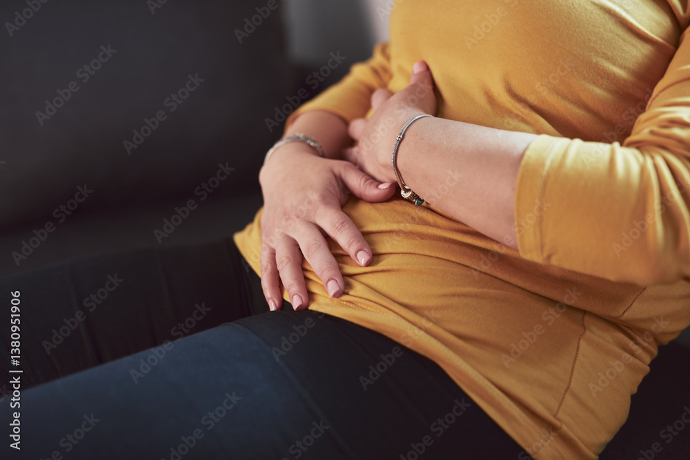 Woman with strong stomach ache, menstrual and digestive issues at home.