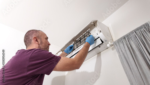 Obraz na płótnie Man cleaning and maintaining air condition unit at home. w salonie