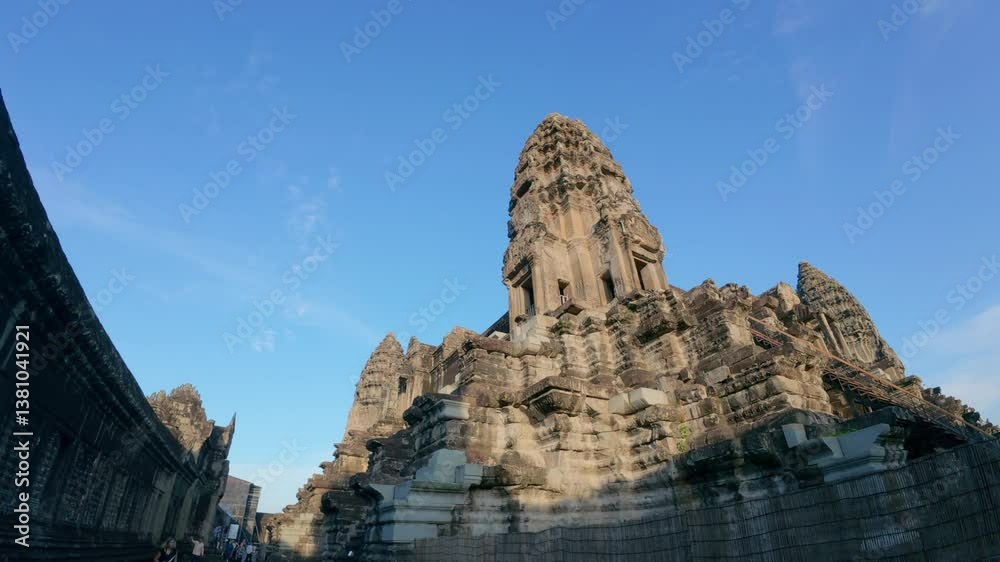 A towering stone temple structure with intricate details, set under a clear blue sky, showcasing historical and architectural significance. Cambodia Angkor Wat Temple A towering stone temple structure with intricate details, set under a clear blue sky, showcasing historical and architectural significance. Cambodia Angkor Wat Temple