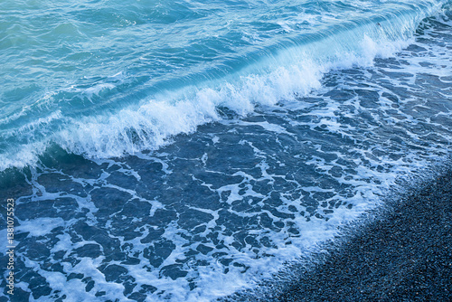 Seashore, pebbles and a small wave
