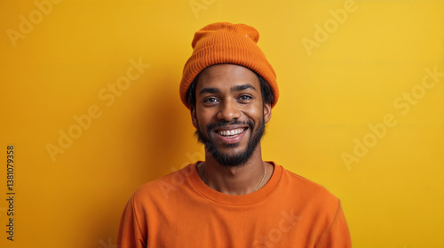 A man wearing an orange hat and shirt is smiling at the camera