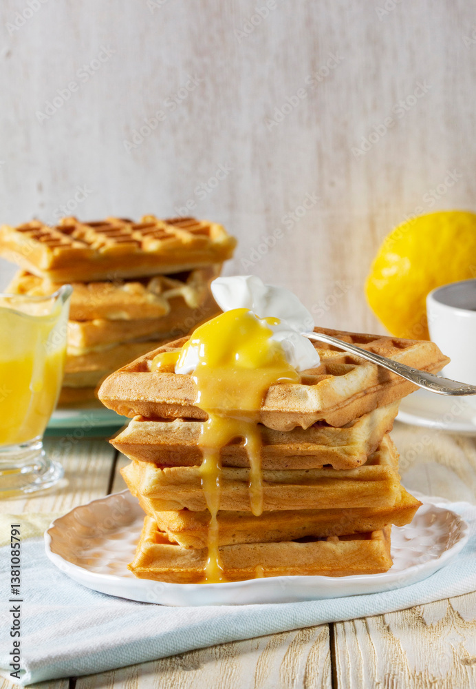 Belgian waffles with cream and lemon curd, served with tea.