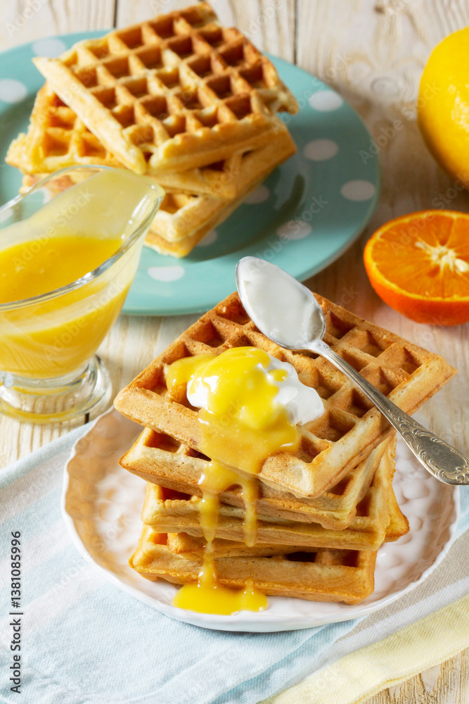 Belgian waffles with cream and lemon curd, served with tea.