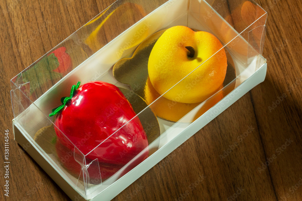 Gift set of mousse cakes in the shape of fruits and berries in a box.