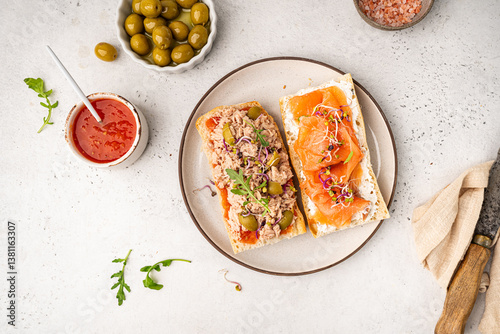 Variety of sandwiches with tuna, salmon y jamon or prosciutto for breakfast on white background, top view, Bruschetta snacks for wine.