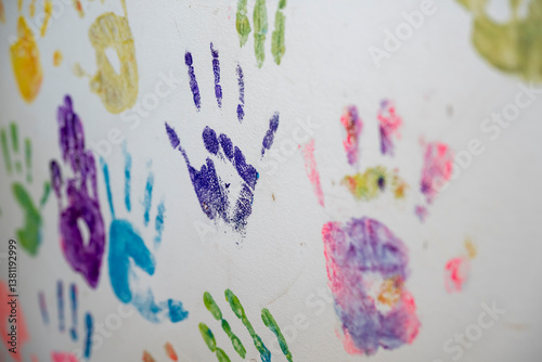 traces de mains avec de la peinture de différentes couleurs sur une surface blanche, mains sur un mur