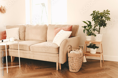 The bright and cozy interior of the living room with a sofa and various decor. Bright apartment with a window and furniture. Selective focus