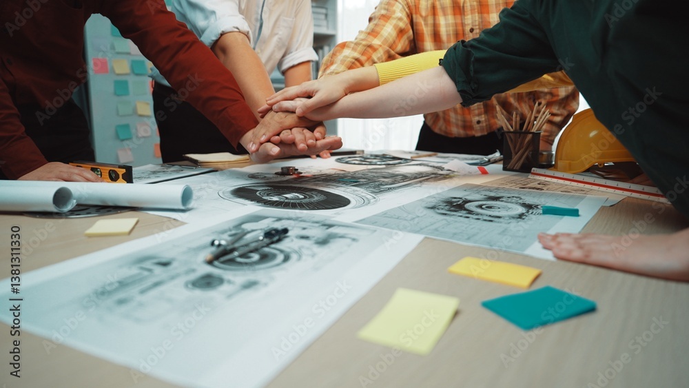 A dynamic workspace captures a team collaborating over designs, showcasing hands united above plans on a table surrounded by notes and tools for effective planning. SACTR A dynamic workspace captures a team collaborating over designs, showcasing hands united above plans on a table surrounded by notes and tools for effective planning. SACTR