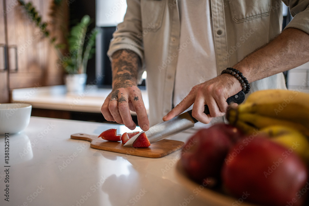 Obraz premium Chef cutting strawberries on wooden board in modern kitchen