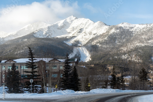 Frisco, Colorado snow capped rocky mountains peak in winter weather sunrise and modern houses apartment condo buildings on street road