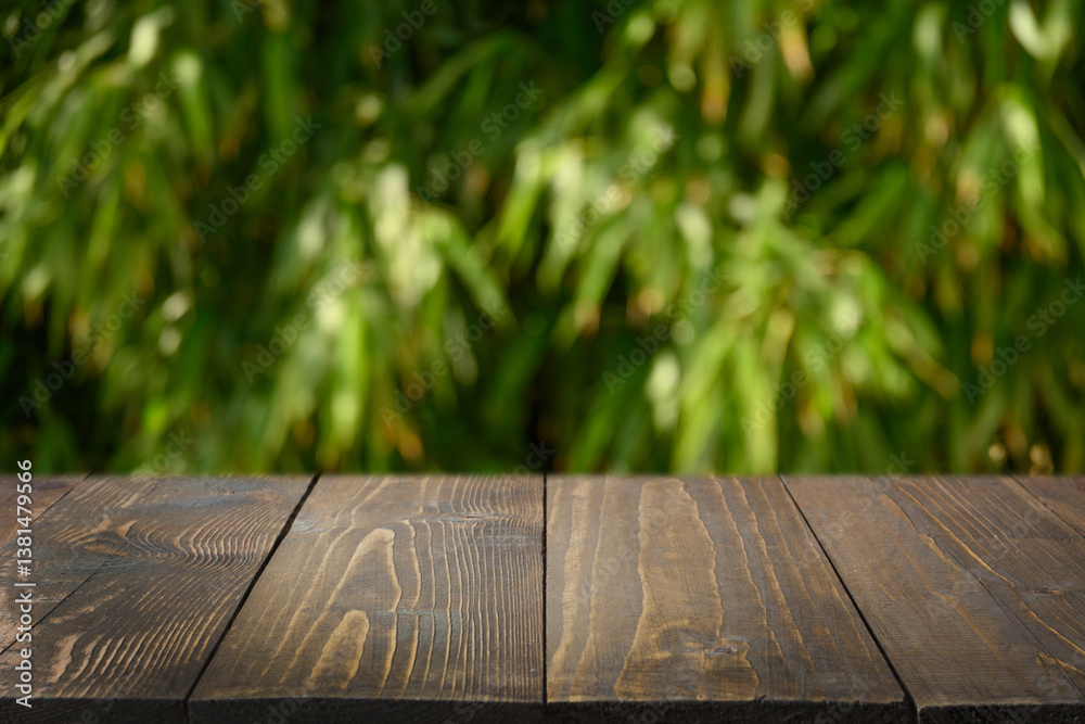 Empty wooden table top against bamboo leaves forest as blurred abstract natural background. Eco tropical background. Space for design. Mock up. Template