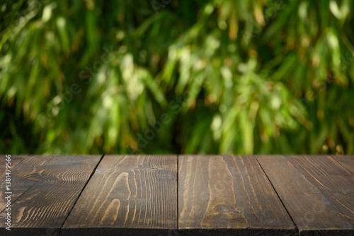 Obraz na płótnie Empty wooden table top against bamboo leaves forest as blurred abstract natural background. Eco tropical background. Space for design. Mock up. Template w salonie