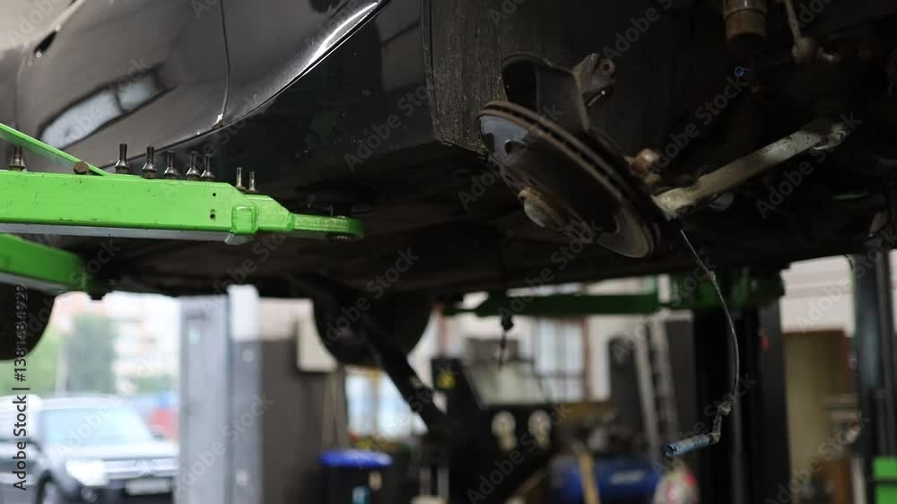 a car in a car service center is being lifted for repairs a car in a car service center is being lifted for repairs