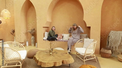 Relaxing conversation in a cozy, earthy-toned indoor space with stylish decor and comfortable seating
