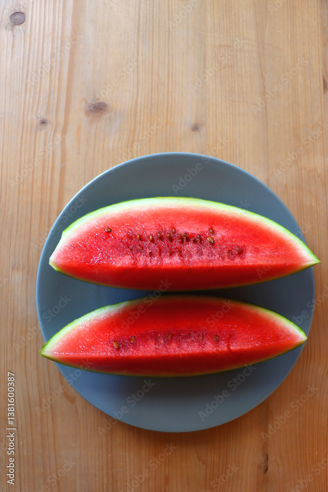 Plate with two watermelon slices on the table. Top view.