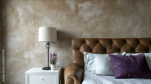 A photo of the wall in an apartment with smooth marmorino plaster on it The color is beigebrown Theres also a white bedside table and a purple pillow next to a bed