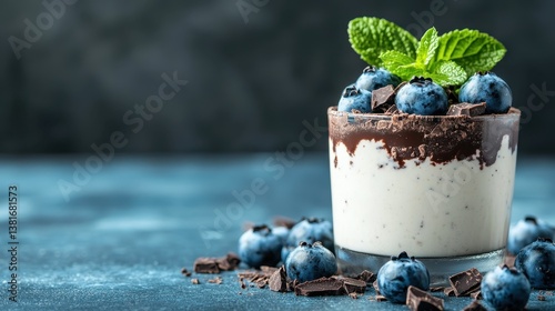 Obraz na płótnie A tempting chocolate dessert topped with fresh blueberries and mint, beautifully presented in a clear glass, ideal for a classy dining experience or dessert display. w salonie