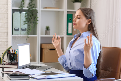 Young businesswoman meditat...