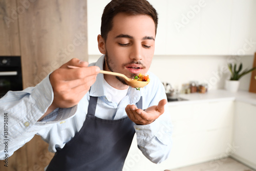 Young man tasting fried veg...