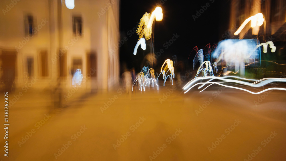 Obraz premium Urban nightscape showing blurred light trails streaming across dark street, revealing dynamic motion and vibrant city energy