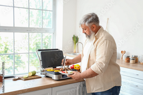 Mature man cooking tasty sa...