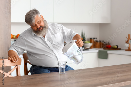 Mature man pouring purified...